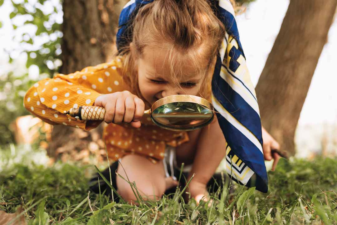 Image of cute kid with magnifying glass exploring the nature out